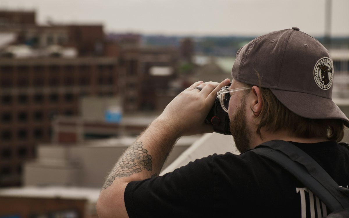 Location scout photographing the city from a rooftop